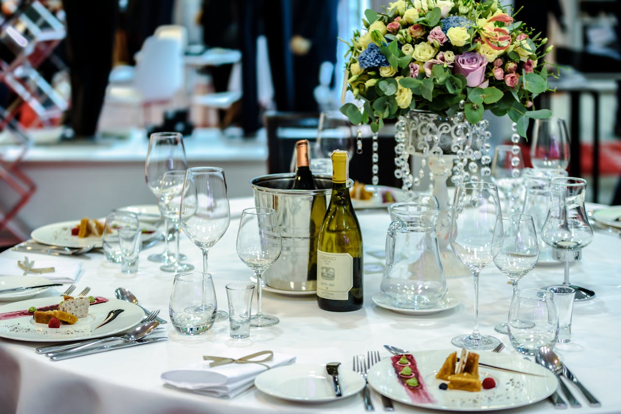 Luxurious dining setup with flowers, wine, and dessert plates, ideal for special occasions.