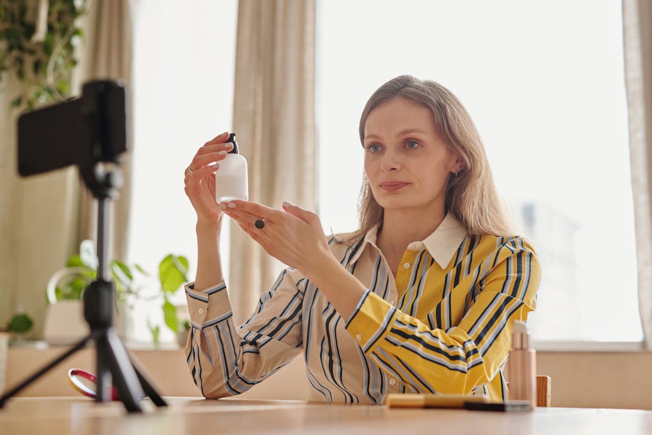 why-choose-us Woman demonstrates skincare product during a vlog in a cozy indoor setting.
